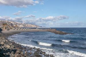 a beach with a rocky shoreline and the ocean at El Ramonal Home in Candelaria