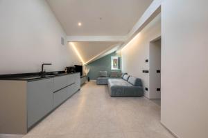 a kitchen and living room with a couch and a sink at App 302 Palazzo Cavour in Bolzano +15 photos