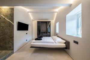 a bedroom with a bed and a tv on a wall at App 302 Palazzo Cavour in Bolzano