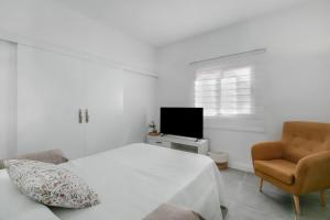 a bedroom with a bed and a chair and a television at El Ramonal Home in Candelaria