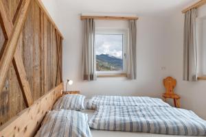 a bedroom with two beds and a window at Haus Pferscher in Barbiano