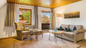 a living room with a couch and a table and chairs at Ferienhaus Unmüßig in Hinterzarten