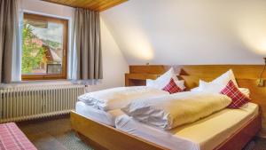 a bedroom with a bed with white sheets and pillows at Ferienhaus Unmüßig in Hinterzarten