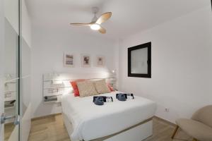 a white bedroom with a bed and a ceiling fan at Lupama Suite in Arguineguín +21 photos