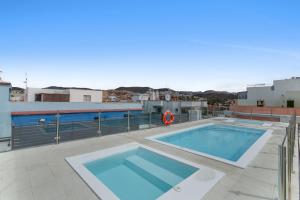 a swimming pool on the roof of a building at Lupama Suite in Arguineguín