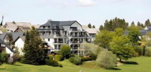a large apartment building on a hill with trees at Wellness Appartement Winterberg E2 in Winterberg