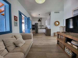 a living room with a couch and a flat screen tv at Villa Delicias in Melenara