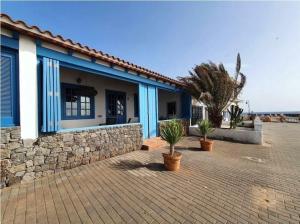 a house with a stone wall and potted plants at Villa Delicias in Melenara