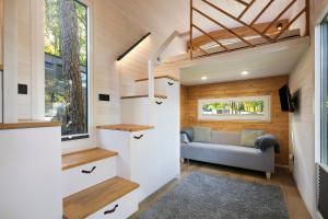 a tiny house with a couch and a window at Tiny House Nr 5 in Schwielowsee