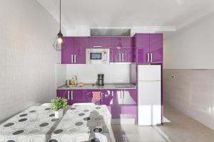 a kitchen with purple cabinets and a white refrigerator at El Nido de los Ángeles in Playa del Ingles