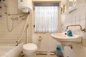 a small bathroom with a toilet and a sink at Bungalow 10 - Finnhütte in Niesky +11 photos