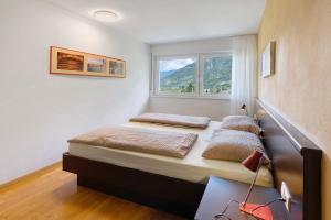 two beds in a room with a window at Marinushof in Kastelbell-Tschars
