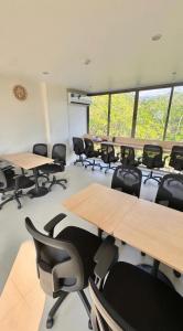 a classroom with desks and chairs in a room with windows at 2BR Fantasea condo kamala in Kamala Beach