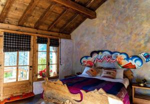 a bedroom with a bed with a painting on the wall at Chalet Atmosfera Res Albert in San Guglielmo