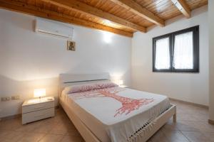 a bedroom with a bed and a window at Casa Silvia in Calasetta