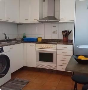 a kitchen with white cabinets and a stove top oven at Villa Lukita in Cangas de Morrazo +15 photos