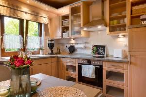 a kitchen with wooden cabinets and a table with a vase of flowers at Ferienhaus Thomas in Colnrade
