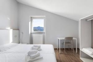 a white bedroom with a bed and a desk at Residenza del Capitano in Levanto