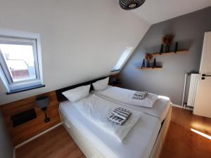 a white bed in a room with a window at Ferienwohnung Möwennest by Deju in Norderney