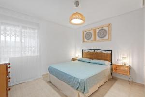 a white bedroom with a bed and a window at Casa Max in Gran Alacant +13 photos