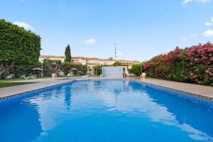a swimming pool in a yard with flowers at Casa Max in Gran Alacant