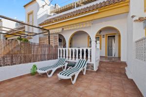 two chairs on a patio in front of a house at Casa Max in Gran Alacant