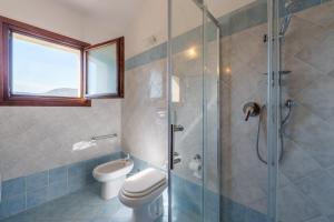 a bathroom with a toilet and a glass shower at Casa Vacanze Cocco in Porto San Paolo
