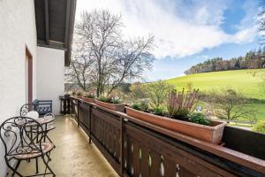 a balcony with benches and potted plants and a field at Dorerhof Prechtal in Elzach