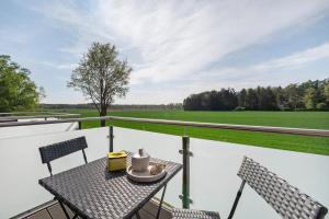 a table and chairs on a balcony with a view of a field at Gästehaus Anna in Suhle