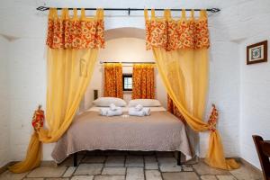 a bedroom with a bed with two stuffed animals on it at Villa Trullo Ulivo with pool in Carovigno +23 photos