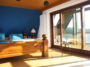 a bedroom with a bed and a large window at Haus Talblick Sasbachwalden in Sasbachwalden
