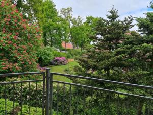 a fence in front of a garden with flowers at Löningen - Ferienwohnung Hasestraße in Löningen