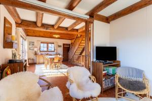 a living room with white chairs and a television at South-facing Chalet With Views in Saint-Chaffrey