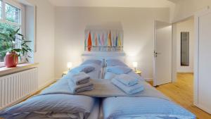a group of four beds in a room with towels at Löningen - Ferienwohnung Hasestraße in Löningen