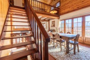a dining room with a wooden staircase and a table and chairs at South-facing Chalet With Views in Saint-Chaffrey