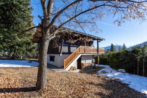 a house with a deck and a tree at South-facing Chalet With Views in Saint-Chaffrey