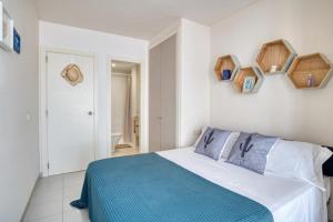 a bedroom with a blue and white bed and a bathroom at Apartamento en 1 línea mar in Sant Antoni de Calonge