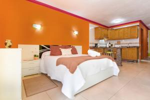 a bedroom with a bed with an orange wall at Arcoiris Al Mar Playa San Marcos in San Marcos