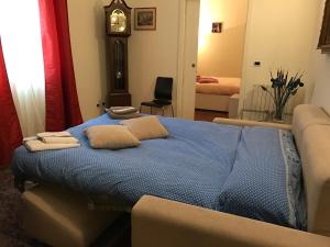 ein Schlafzimmer mit einem Bett mit blauer Bettwäsche und einer Uhr in der Unterkunft TL Palazzo Fantuzzi in Bologna
