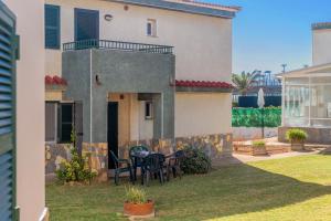 a house with a table and chairs in the yard at Cala en Forcat in Menorca