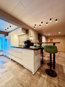 a kitchen with a counter and a table and a stool at Lot54 Holiday Homes in Feuerscheid
