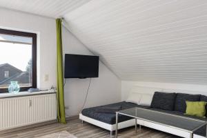 a living room with a couch and a tv at Heidi's Panoramablick in Neuerode