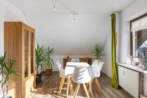 a dining room with a table and white chairs at Heidi's Panoramablick in Neuerode
