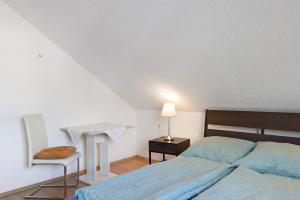 a bedroom with a bed and a table and a chair at Heidi's Panoramablick in Neuerode