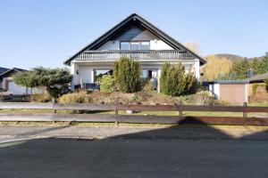 a house with a fence in front of it at Heidi's Panoramablick in Neuerode