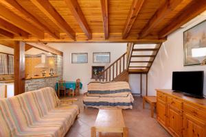 a living room with a couch and a staircase at Maison de village Le Galbe in La Llagonne