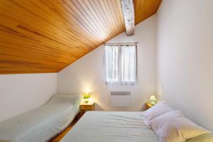 a bedroom with two beds and a wooden ceiling at Maison de village Le Galbe in La Llagonne