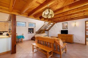 a living room with a bench and a staircase at Maison de village Le Galbe in La Llagonne