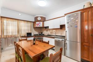 a kitchen with a wooden table and a stainless steel refrigerator at Casa ino in Punta del Hidalgo