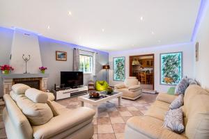 a living room with white couches and a tv at Casa do Sobreiro in Quelfes